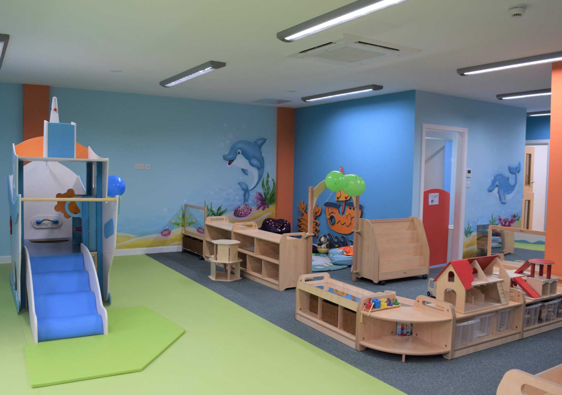 Playroom with a small slide and wooden play units