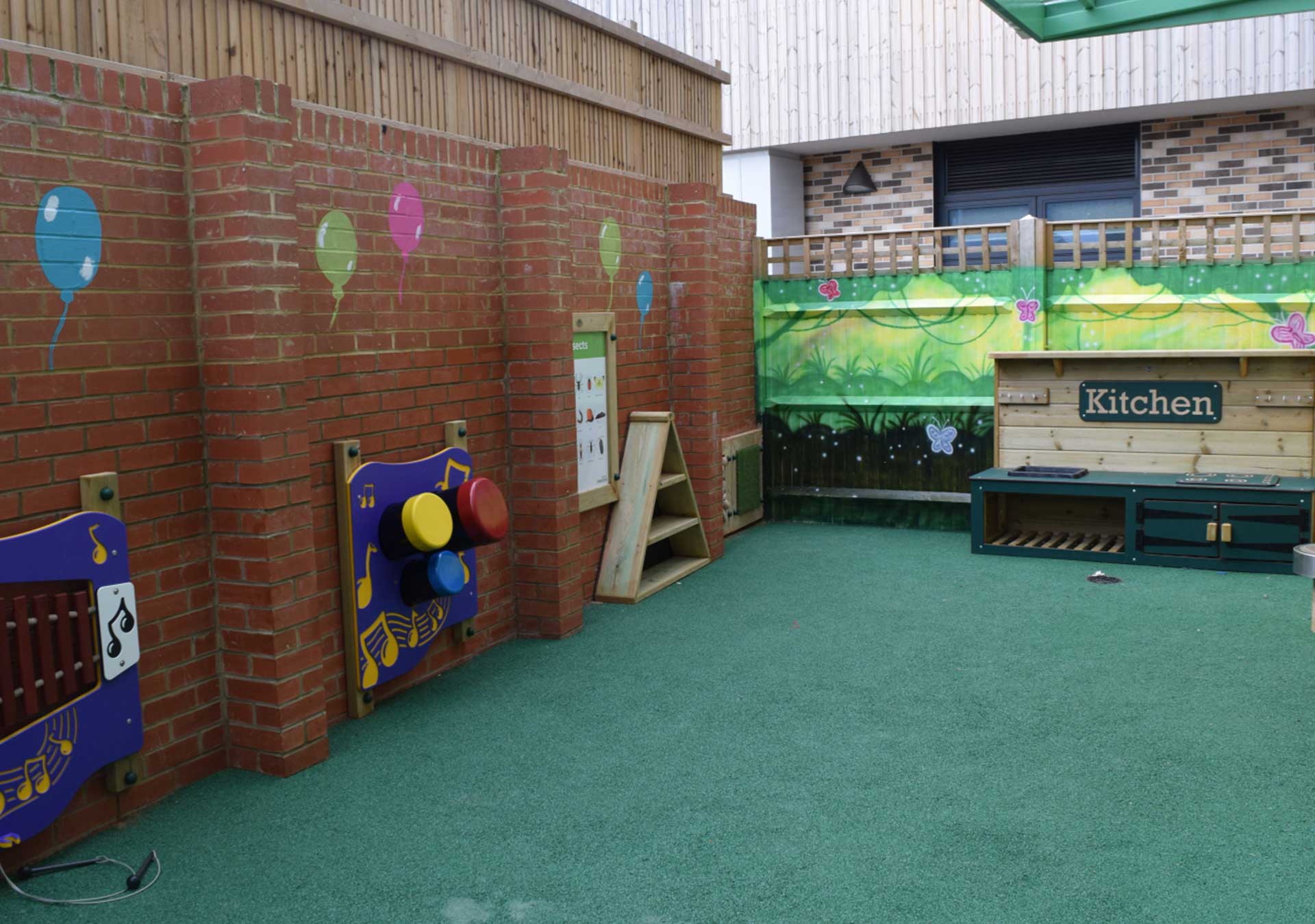 Garden wall with sensory play panels and balloon decorations