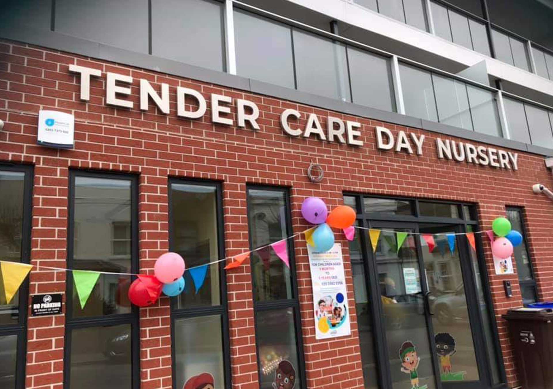 Tender Care Day Nursery sign above the entrance with balloons and bunting