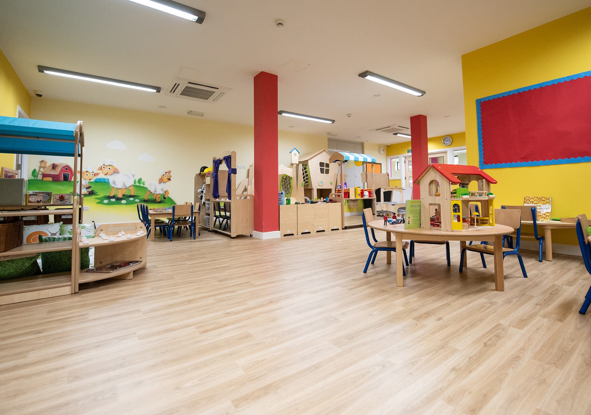 Colourful playroom with a toy house and wooden play furniture
