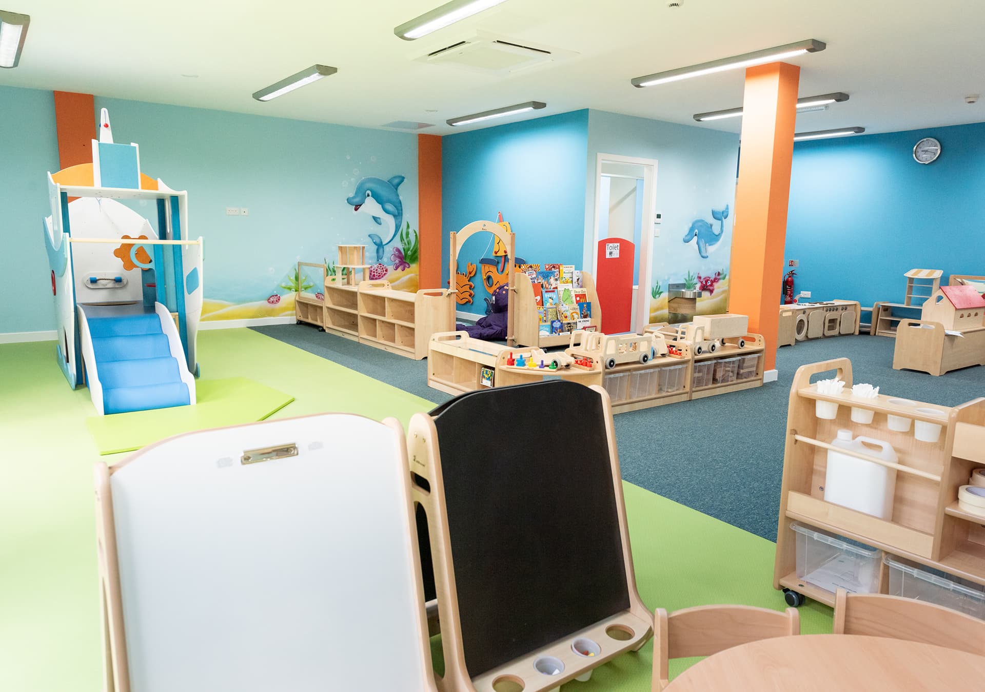 Play room with a slide, chalkboard and easel