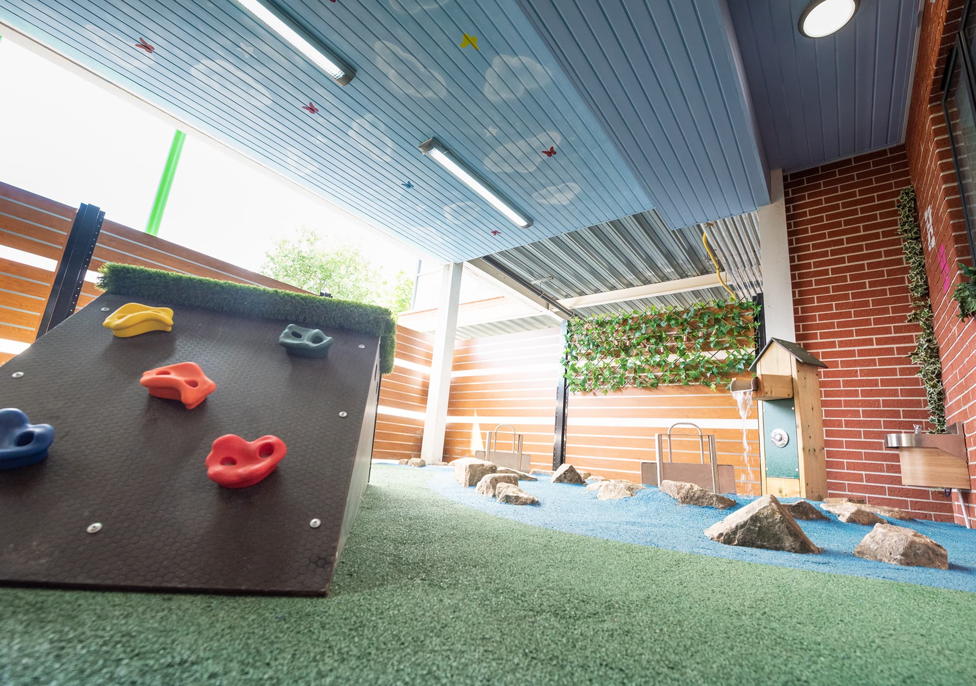 Covered outdoor play area with a climbing ramp