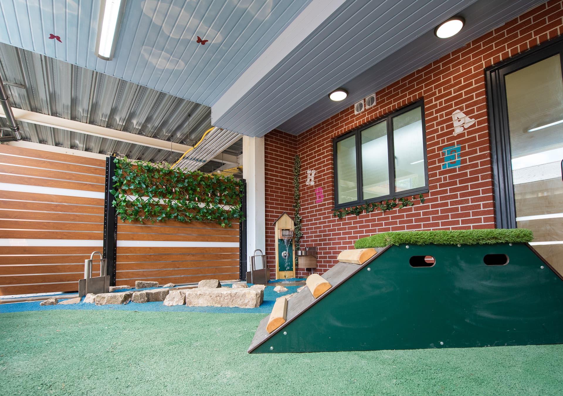 Covered outdoor area with a climbing ramp and brick walls
