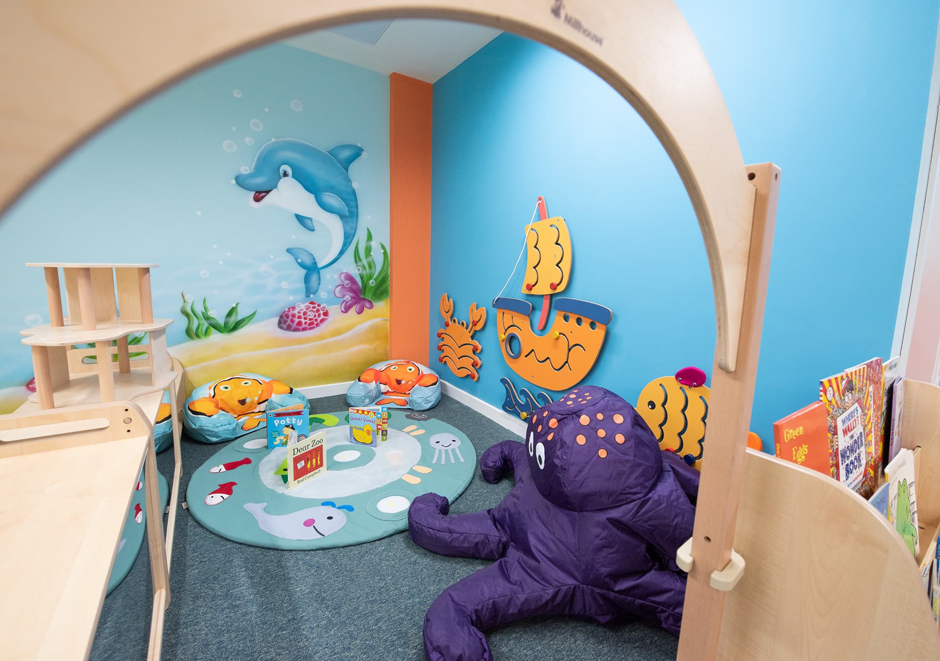 Sea-themed reading and play corner with a purple octopus toy