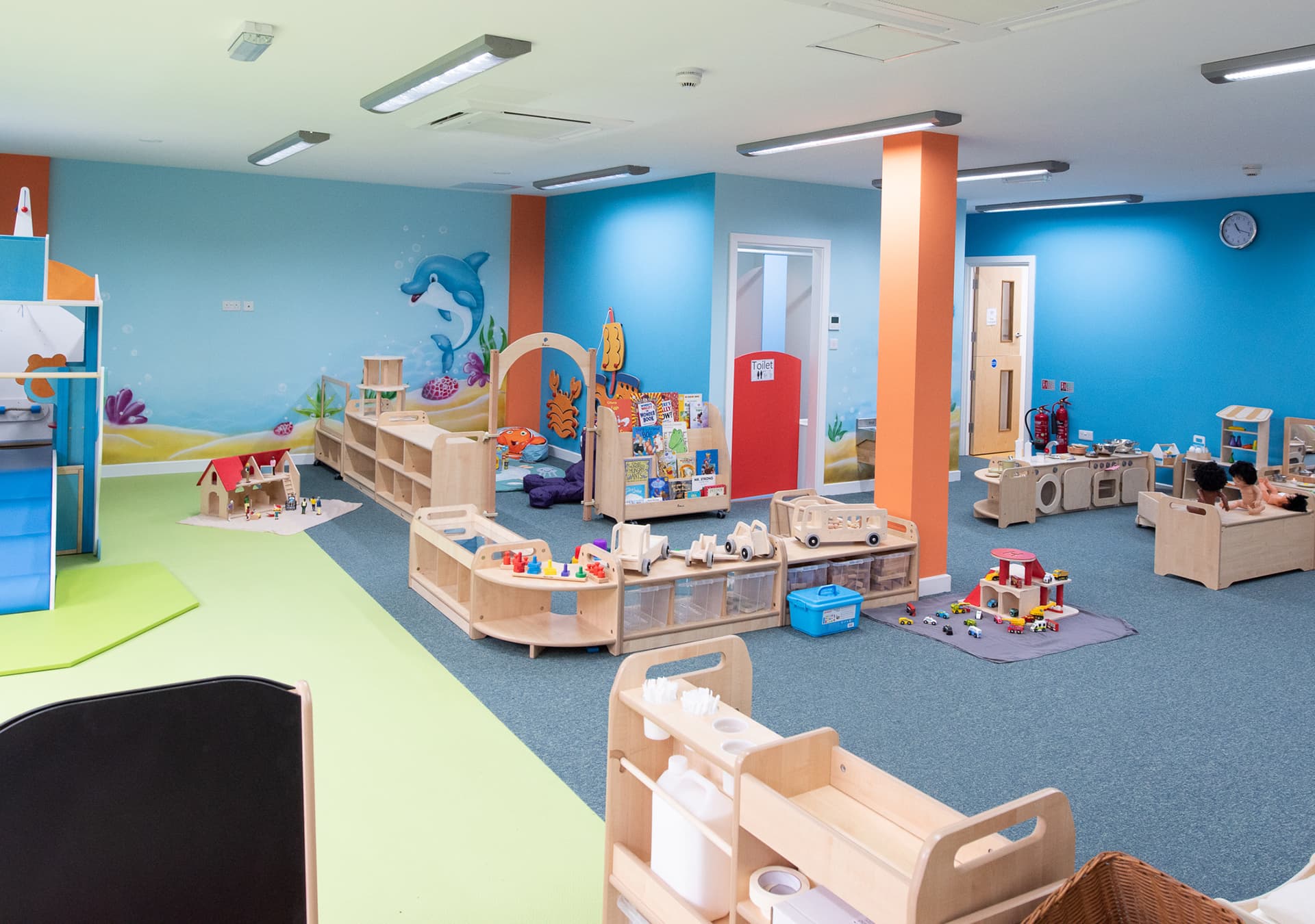 Bright playroom with blue walls, toys and play furniture