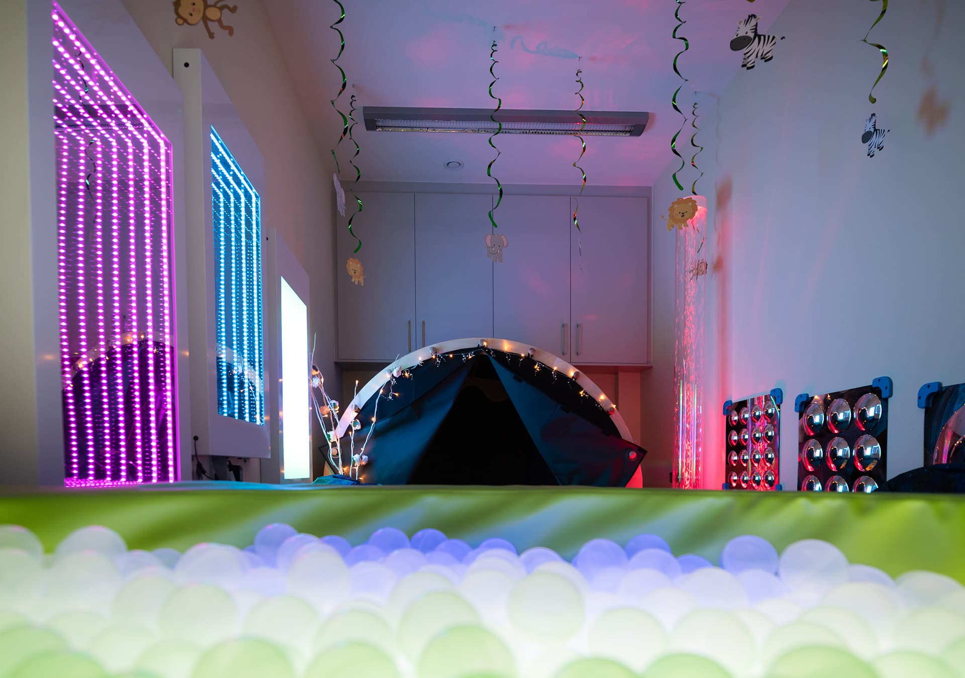Sensory room with coloured lights, a sensory tent and a ball pit