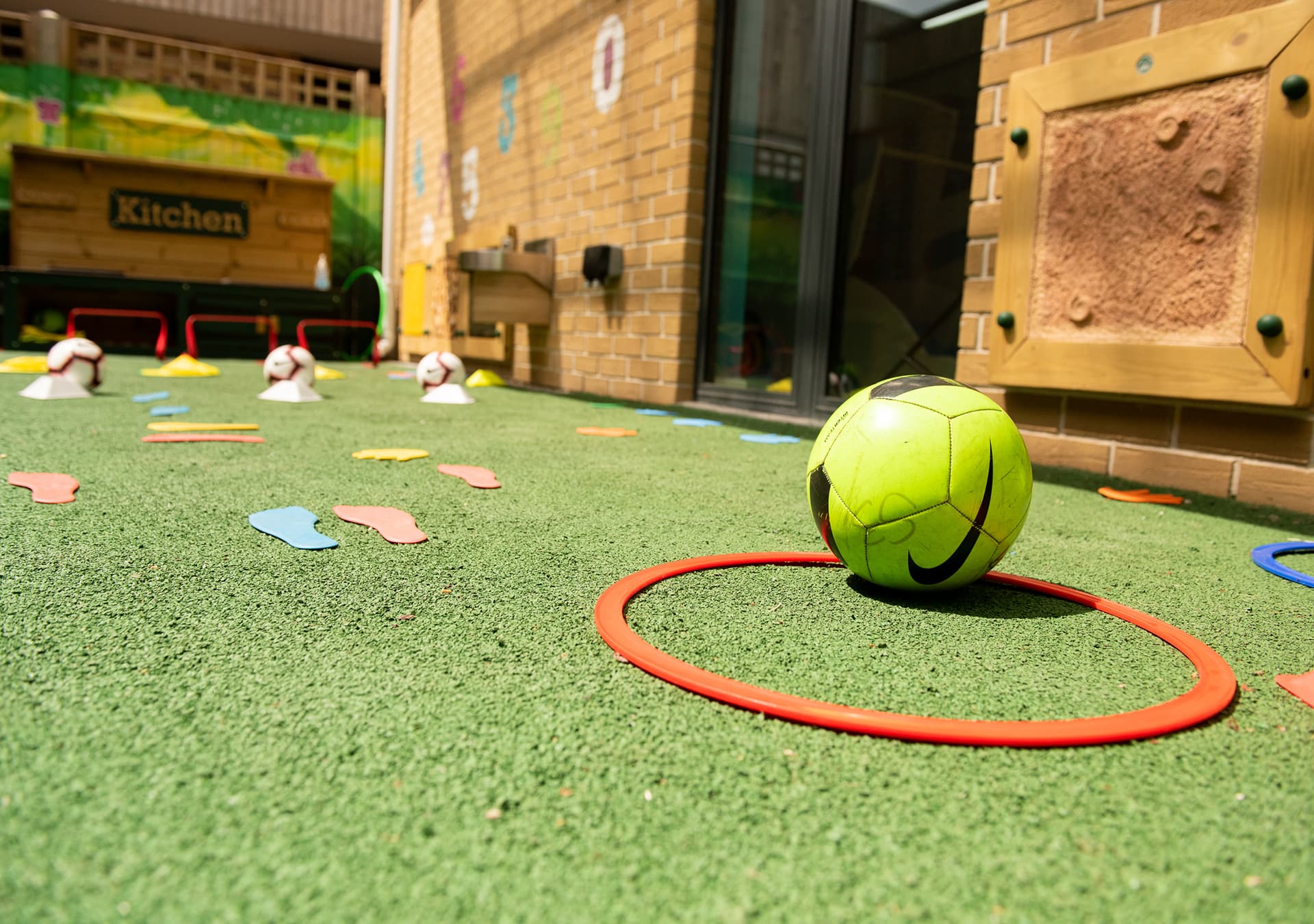 Soft ball and hoop on artificial grass in the indoor garden